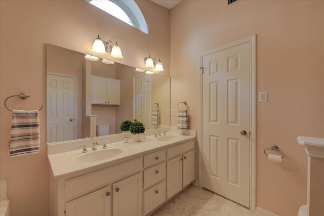 7925 Wheel Rim Cir, Austin, TX 78749 - bathroom featuring toilet, double vanity, and baseboards