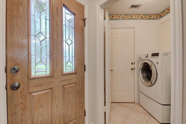 7925 Wheel Rim Cir, Austin, TX 78749 - washroom featuring washer / clothes dryer, light tile patterned floors, and a textured ceiling