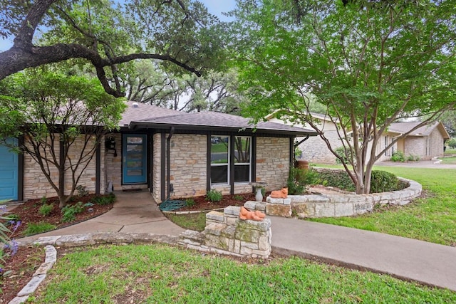 11505 Circle Bend Dr, Austin, TX 78758 - view of front of home with stone siding, a shingled roof, and a front yard