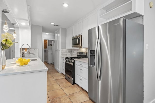 11505 Circle Bend Dr, Austin, TX 78758 - kitchen featuring appliances with stainless steel finishes, a sink, tasteful backsplash, white cabinetry, and light tile patterned floors
