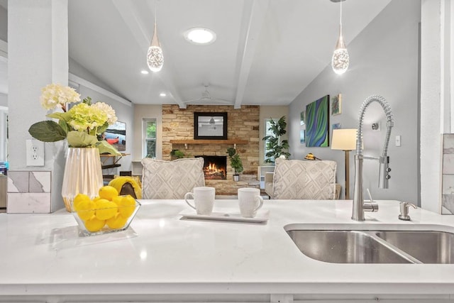11505 Circle Bend Dr, Austin, TX 78758 - kitchen with a sink, a fireplace, beam ceiling, and pendant lighting