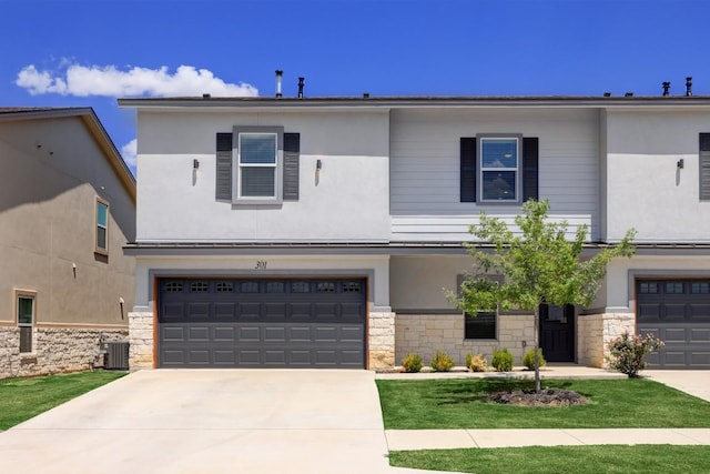 2105 Tiger Trl Unit 301, Round Rock, TX 78664 - view of front of home featuring a garage, stone siding, cooling unit, and driveway