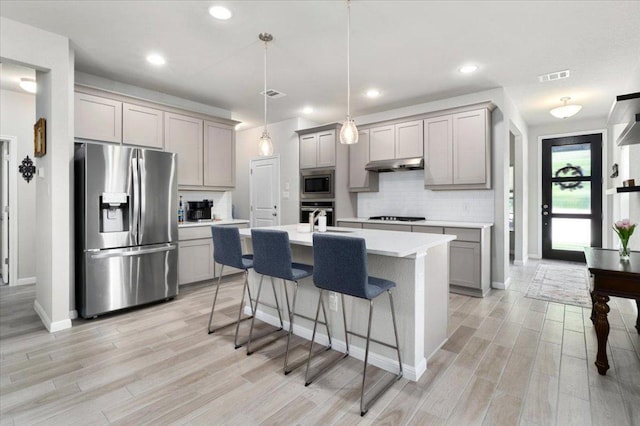 129 Lacey Oak Loop, San Marcos, TX 78666 - kitchen with appliances with stainless steel finishes, gray cabinets, under cabinet range hood, decorative backsplash, and recessed lighting