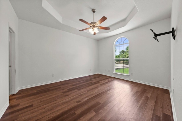 136 W Maple Dr, Granite Shoals, TX 78654 - empty room featuring a raised ceiling, dark wood-type flooring, a ceiling fan, and baseboards