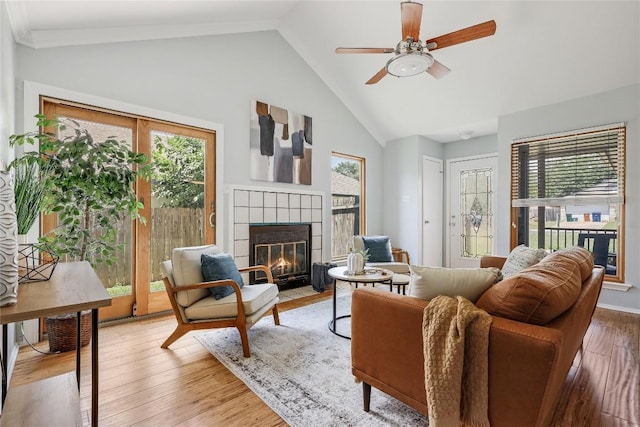 12319 Emery Oaks Rd, Austin, TX 78758 - living room featuring a tiled fireplace, ceiling fan, wood finished floors, and high vaulted ceiling
