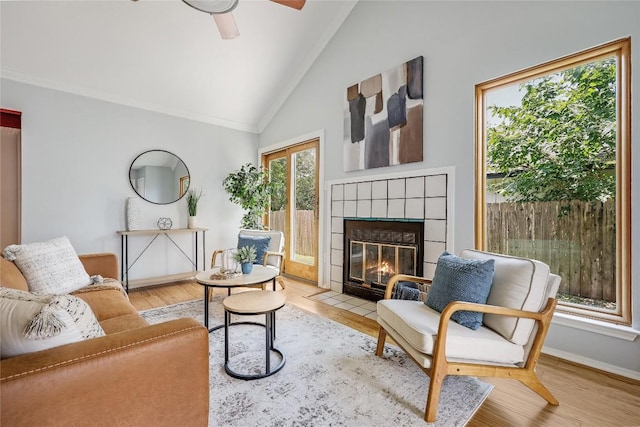 12319 Emery Oaks Rd, Austin, TX 78758 - living area with a tile fireplace, baseboards, ceiling fan, wood finished floors, and high vaulted ceiling