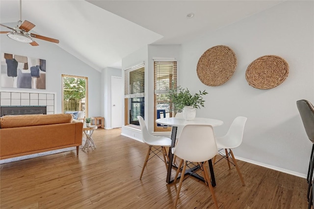 12319 Emery Oaks Rd, Austin, TX 78758 - dining room featuring a tile fireplace, ceiling fan, light wood finished floors, and lofted ceiling