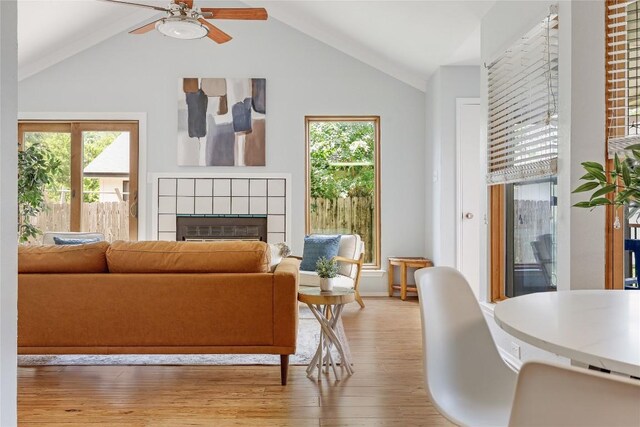 12319 Emery Oaks Rd, Austin, TX 78758 - living room with plenty of natural light, light wood-type flooring, a tiled fireplace, ceiling fan, and vaulted ceiling