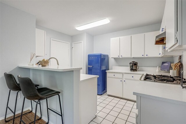 12319 Emery Oaks Rd, Austin, TX 78758 - kitchen with light countertops, a kitchen bar, white cabinets, and a peninsula