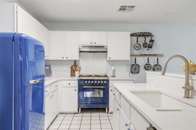 12319 Emery Oaks Rd, Austin, TX 78758 - kitchen with refrigerator, high end black range oven, under cabinet range hood, light countertops, and light tile patterned flooring