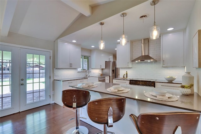 2905 Greenlawn Pkwy, Austin, TX 78757 - kitchen featuring wall chimney range hood, stainless steel appliances, a breakfast bar, tasteful backsplash, and recessed lighting