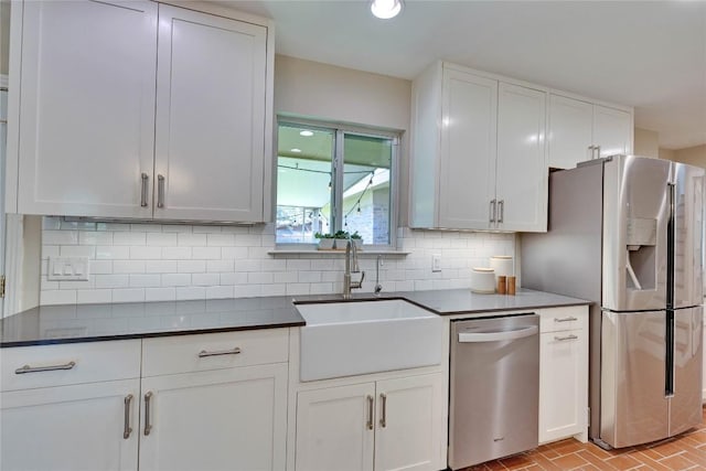 2905 Greenlawn Pkwy, Austin, TX 78757 - kitchen featuring stainless steel appliances, a sink, dark countertops, tasteful backsplash, and white cabinetry