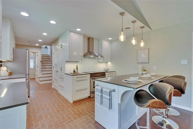 2905 Greenlawn Pkwy, Austin, TX 78757 - kitchen with wall chimney range hood, high end stainless steel range, white cabinets, baseboards, and recessed lighting