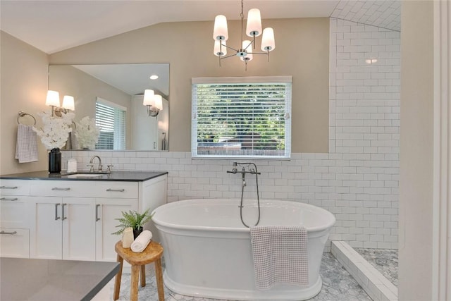 2905 Greenlawn Pkwy, Austin, TX 78757 - bathroom with lofted ceiling, a chandelier, tile walls, vanity, and a freestanding bath