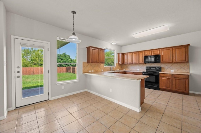 215 Gainer Dr, Hutto, TX 78634 - kitchen featuring black appliances, light countertops, tasteful backsplash, a peninsula, and brown cabinets