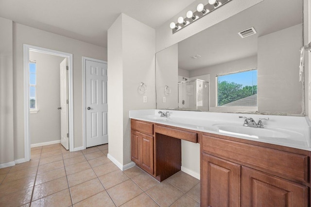 215 Gainer Dr, Hutto, TX 78634 - full bathroom with double vanity, a stall shower, tile patterned flooring, and baseboards