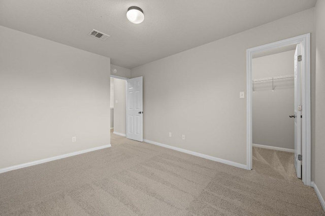 215 Gainer Dr, Hutto, TX 78634 - unfurnished bedroom featuring carpet floors, baseboards, a walk in closet, and a closet