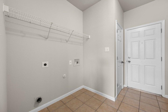 215 Gainer Dr, Hutto, TX 78634 - laundry room featuring hookup for an electric dryer, washer hookup, light tile patterned floors, and baseboards
