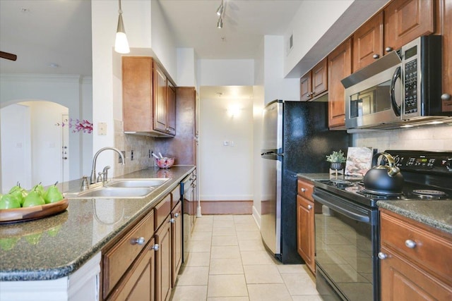 7701 Rialto Blvd Unit 1232, Austin, TX 78735 - kitchen featuring appliances with stainless steel finishes, a sink, arched walkways, backsplash, and light tile patterned flooring