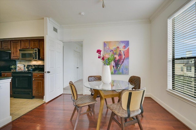 7701 Rialto Blvd Unit 1232, Austin, TX 78735 - dining room featuring light wood-style flooring, crown molding, and baseboards