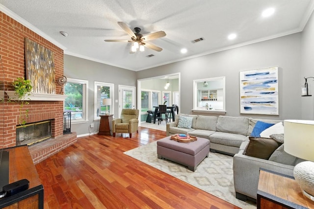 10408 Cassia Dr, Austin, TX 78759 - living room with a ceiling fan, wood finished floors, crown molding, a brick fireplace, and baseboards