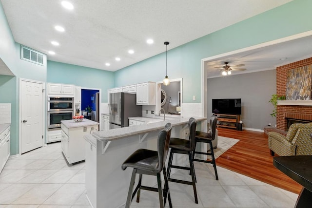 10408 Cassia Dr, Austin, TX 78759 - kitchen with appliances with stainless steel finishes, a peninsula, recessed lighting, light countertops, and a breakfast bar area