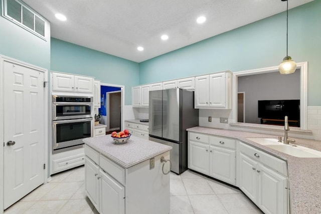 10408 Cassia Dr, Austin, TX 78759 - kitchen with stainless steel appliances, a sink, white cabinetry, recessed lighting, and light tile patterned floors