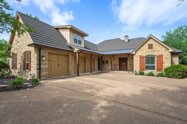 3602 Red Cedar Ct, Bryan, TX 77807 - view of front of property with stone siding, concrete driveway, a standing seam roof, and an attached garage