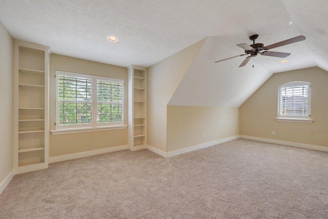 3602 Red Cedar Ct, Bryan, TX 77807 - additional living space with a textured ceiling, carpet floors, baseboards, and lofted ceiling