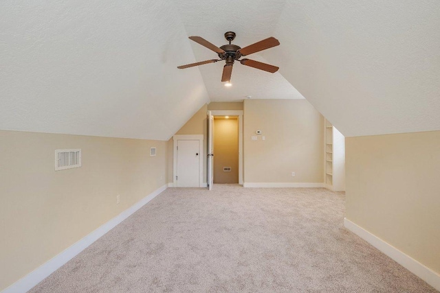 3602 Red Cedar Ct, Bryan, TX 77807 - additional living space with ceiling fan, lofted ceiling, light colored carpet, a textured ceiling, and baseboards