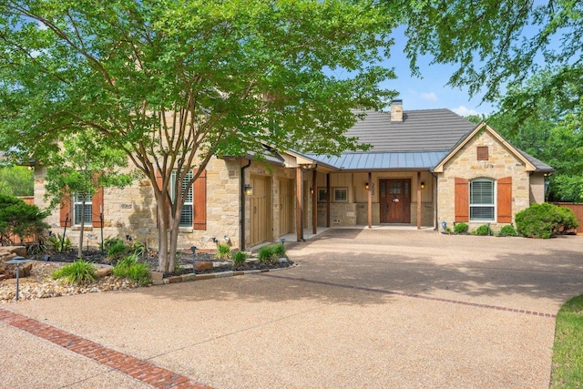 3602 Red Cedar Ct, Bryan, TX 77807 - view of front of home with stone siding, driveway, a standing seam roof, and a garage