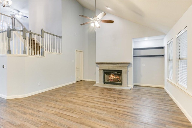 2709 Melba Pass, Cedar Park, TX 78613 - unfurnished living room featuring ceiling fan, wood finished floors, a warm lit fireplace, and high vaulted ceiling