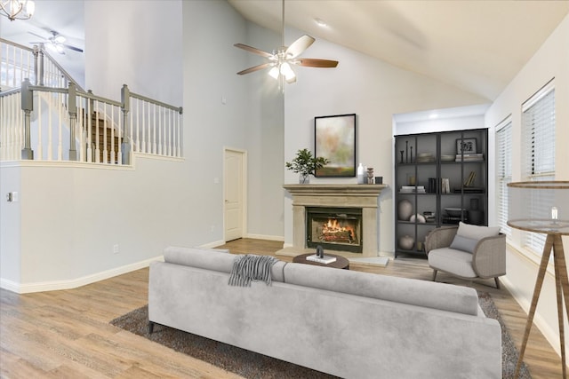 2709 Melba Pass, Cedar Park, TX 78613 - living area featuring a ceiling fan, wood finished floors, a lit fireplace, baseboards, and high vaulted ceiling