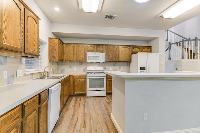 2709 Melba Pass, Cedar Park, TX 78613 - kitchen featuring white appliances, a sink, light wood-style floors, brown cabinets, and decorative backsplash