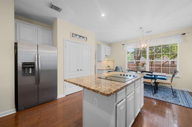 5302 Austral Loop, Austin, TX 78739 - kitchen featuring stainless steel fridge with ice dispenser, black electric stovetop, a chandelier, dark wood finished floors, and a kitchen island