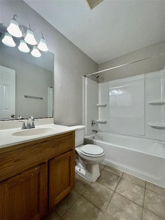 1933 Lisa Ln, San Marcos, TX 78666 - bathroom featuring tile patterned flooring, vanity, shower / washtub combination, toilet, and a textured wall