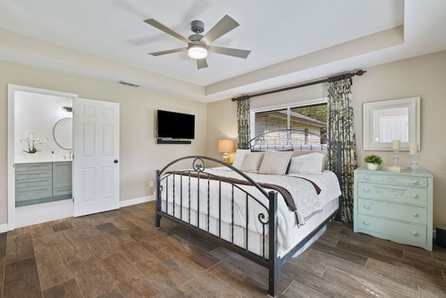 3701 Arrowhead Cir, Round Rock, TX 78681 - bedroom with wood finished floors, a tray ceiling, ensuite bathroom, and a ceiling fan