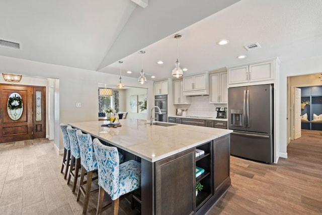 3701 Arrowhead Cir, Round Rock, TX 78681 - kitchen featuring appliances with stainless steel finishes, vaulted ceiling, a large island with sink, white cabinetry, and recessed lighting