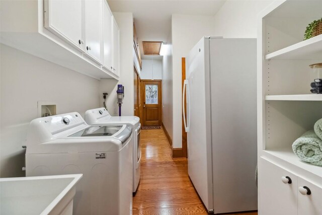 402 Lander Ln, Dripping Springs, TX 78620 - laundry area featuring washer and clothes dryer, light wood-style floors, and cabinet space