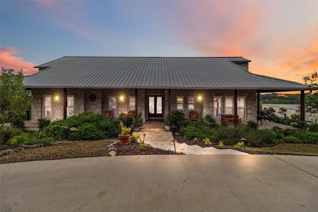 402 Lander Ln, Dripping Springs, TX 78620 - view of front of house with covered porch, metal roof, and stone siding