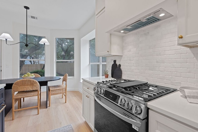 5209 Concho Creek Bnd, Austin, TX 78735 - kitchen with stainless steel gas range, custom exhaust hood, backsplash, and white cabinetry