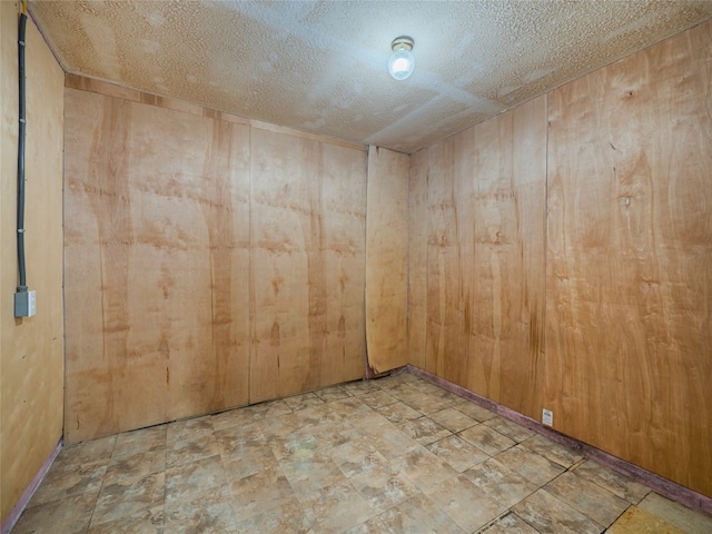 1021 Gardner Rd, Austin, TX 78721 - empty room with wood walls and a textured ceiling