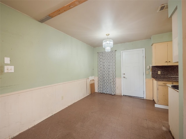 1021 Gardner Rd, Austin, TX 78721 - unfurnished dining area with a wainscoted wall, a chandelier, and tile patterned floors