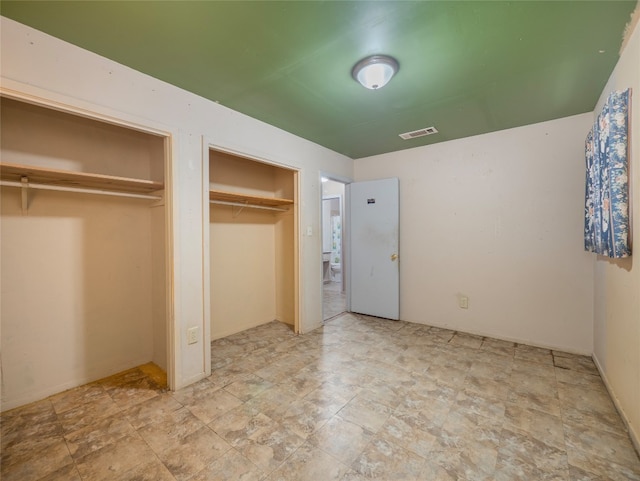 1021 Gardner Rd, Austin, TX 78721 - unfurnished bedroom with stone finish floors and two closets