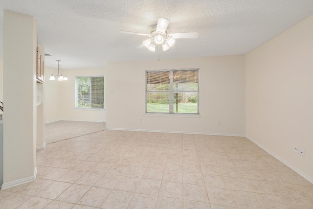 2202 Clayton Way, Cedar Park, TX 78613 - spare room featuring a textured ceiling, a ceiling fan, a chandelier, light tile patterned floors, and baseboards