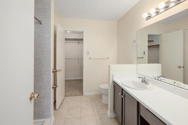 2202 Clayton Way, Cedar Park, TX 78613 - bathroom with a walk in closet, vanity, toilet, tile patterned floors, and a textured ceiling