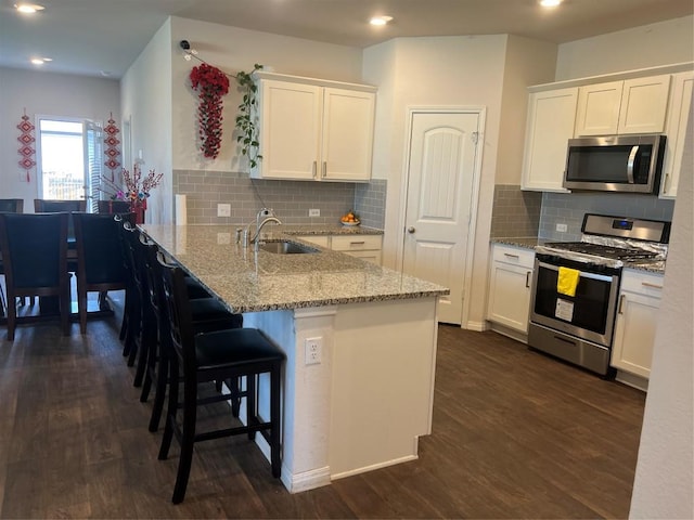 201 Abby Rd, Georgetown, TX 78626 - kitchen featuring appliances with stainless steel finishes, a sink, a peninsula, white cabinets, and dark wood-style floors