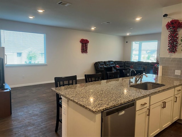 201 Abby Rd, Georgetown, TX 78626 - kitchen featuring dishwasher, a sink, a breakfast bar, white cabinets, and light stone countertops