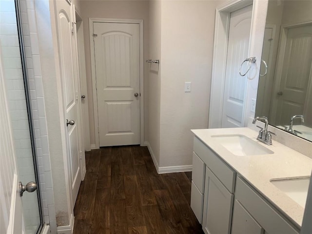 201 Abby Rd, Georgetown, TX 78626 - bathroom featuring wood finished floors, baseboards, double vanity, and a shower with door