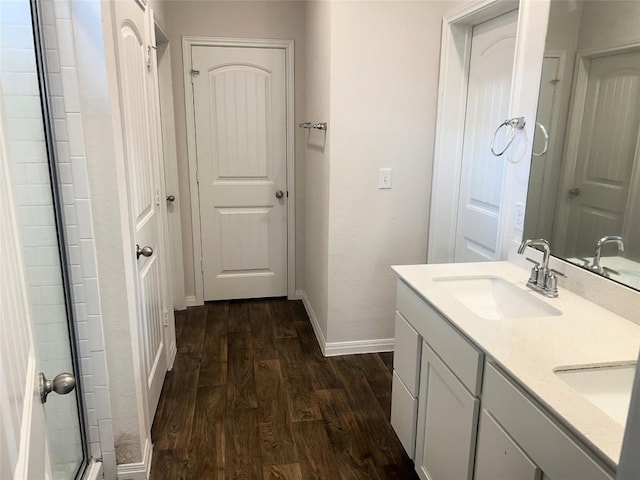201 Abby Rd, Georgetown, TX 78626 - bathroom featuring wood finished floors, baseboards, double vanity, and an enclosed shower